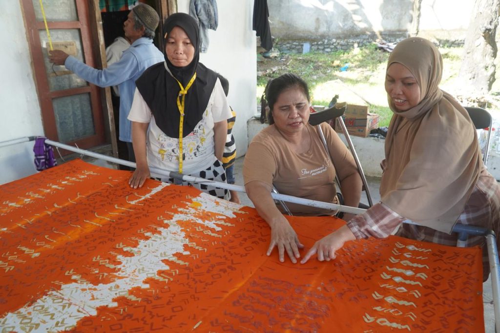 Ibu Nia dan anggota HWDI yang lain sedang memeriksa tekstur kain batik setelah selesai diberi warna